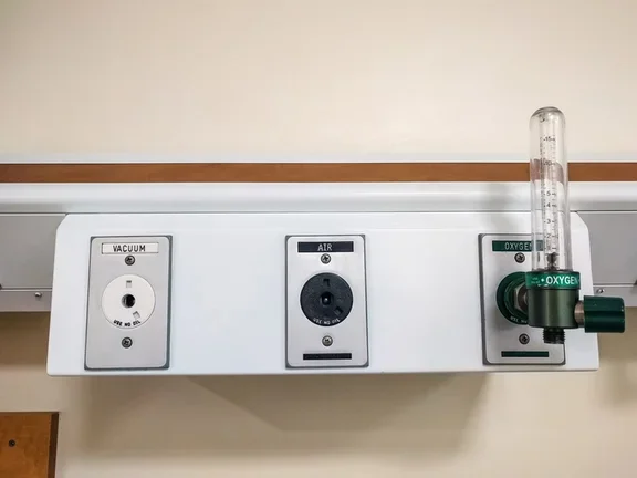 Panel hospitalario con tomas de vacío, aire medicinal y oxígeno.